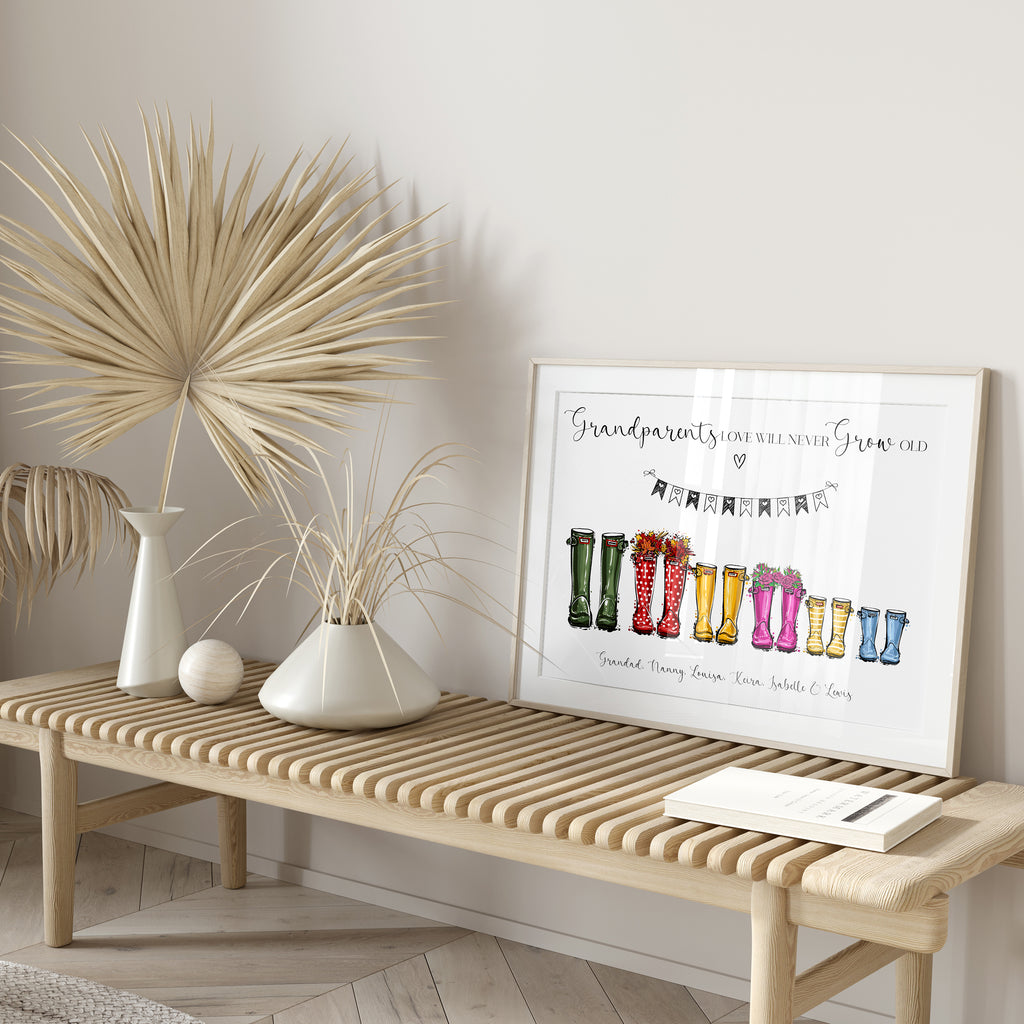 Unframed personalised welly boot print for Nana and Grandad laid flat on wooden surface